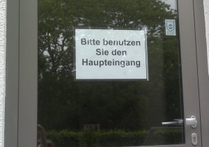 Schild mit dem Text: Bitte benutzen Sie den Haupteingang